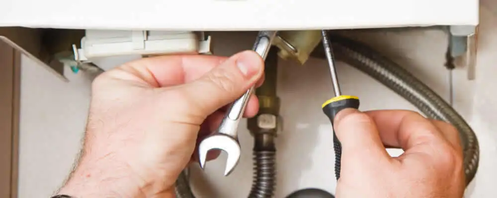 Boiler repair technician tightening pipe fittings and connections in Seattle, WA