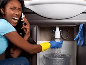 Emergency plumbing repair for a leaking sink drain under a bathroom vanity in Seattle, WA