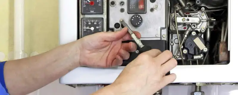 Heating repair technician adjusting boiler controls and components in Seattle, WA