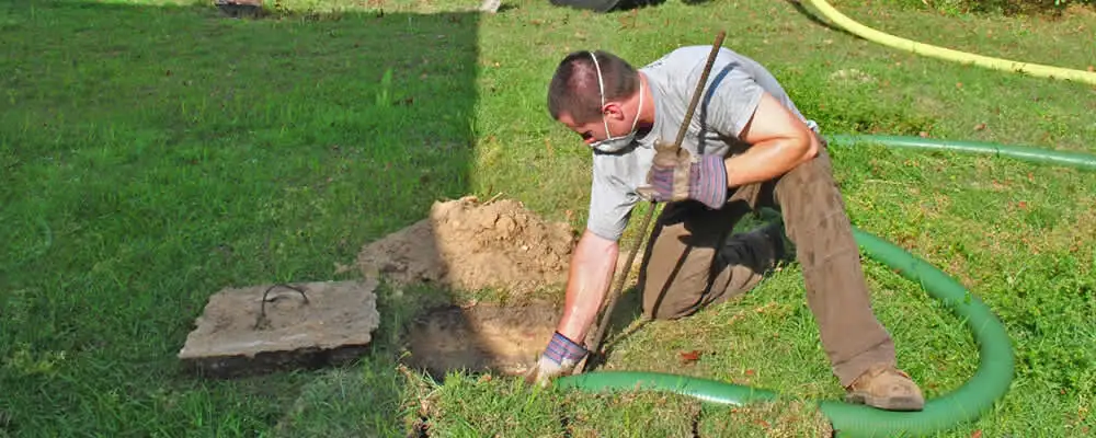 Septic pumping technician servicing a residential septic tank in Seattle, WA